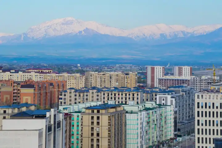 Apartment blocks in Tashkent with snow-capped mountains on the horizon