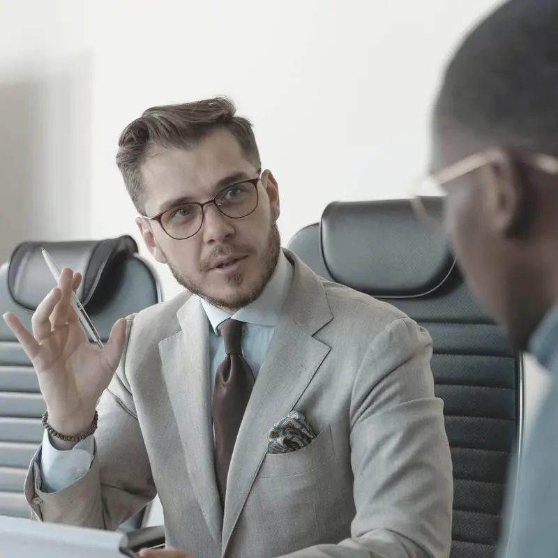 An adviser explaining the next step to a client across a meeting table