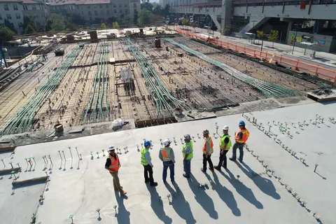 A crew in hard hats looking over a building site